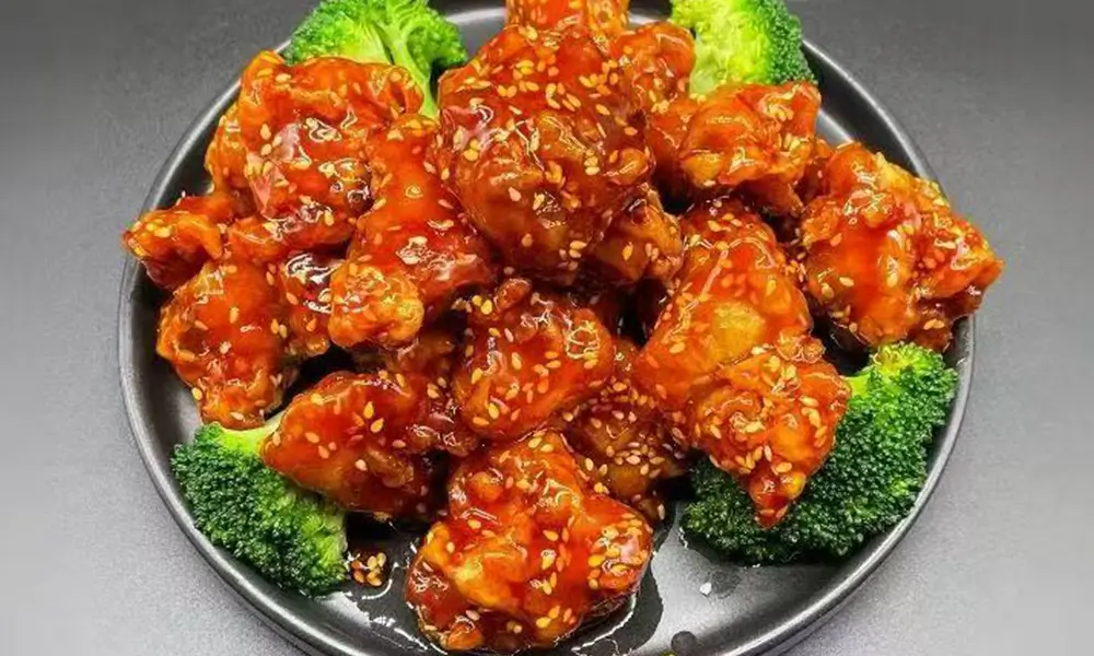 Crispy chicken pieces coated in sweet sesame sauce, served with broccoli at Nihao, a Chinese Restaurant in Lexington